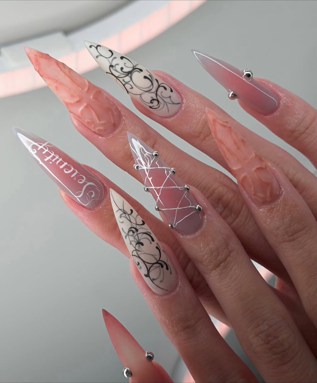 Ethereal Serenity Nude and Gray Stiletto Nails with Baroque Script and 3D Cross Design